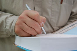 man writing in book